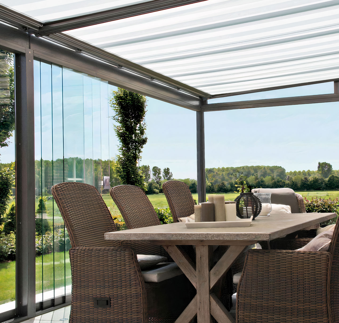 Eine Terrassenüberdachung mit Glaseindeckung und Unterdachmarkise. Die Unterdachmarkisen sind hellgrau und geschlossen.