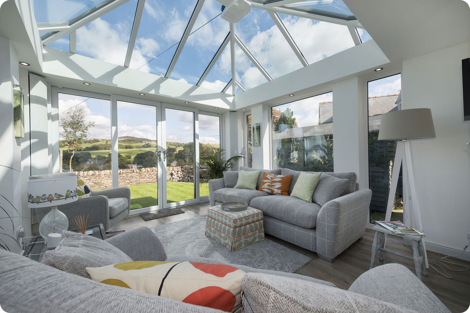 Heller Wintergarten mit hohen Decken und Fensterflächen, der eine entspannende Aussicht auf den Garten bietet.